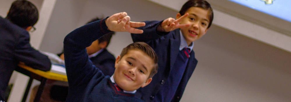 Alumnos del Colegio Álamos saludan sonrientes en el salón